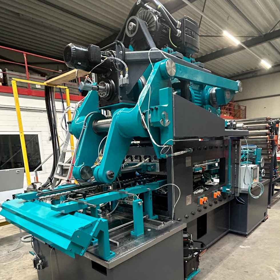 Industrial wide-die thread rolling machine with rollers, guides, and a feeding system in a production hall.