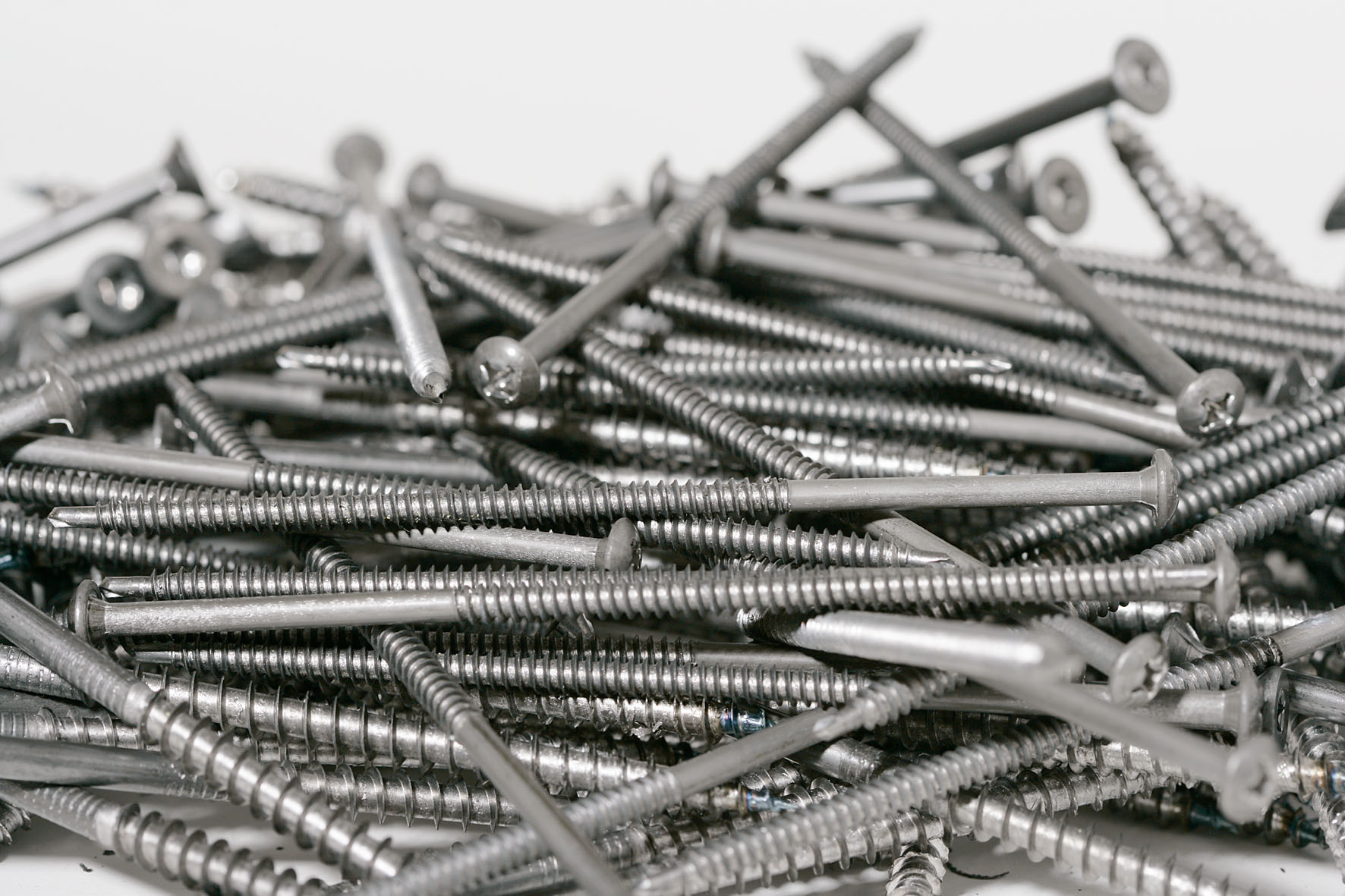 A pile of silver-colored wood screws manufactured on AMBA screw making machines