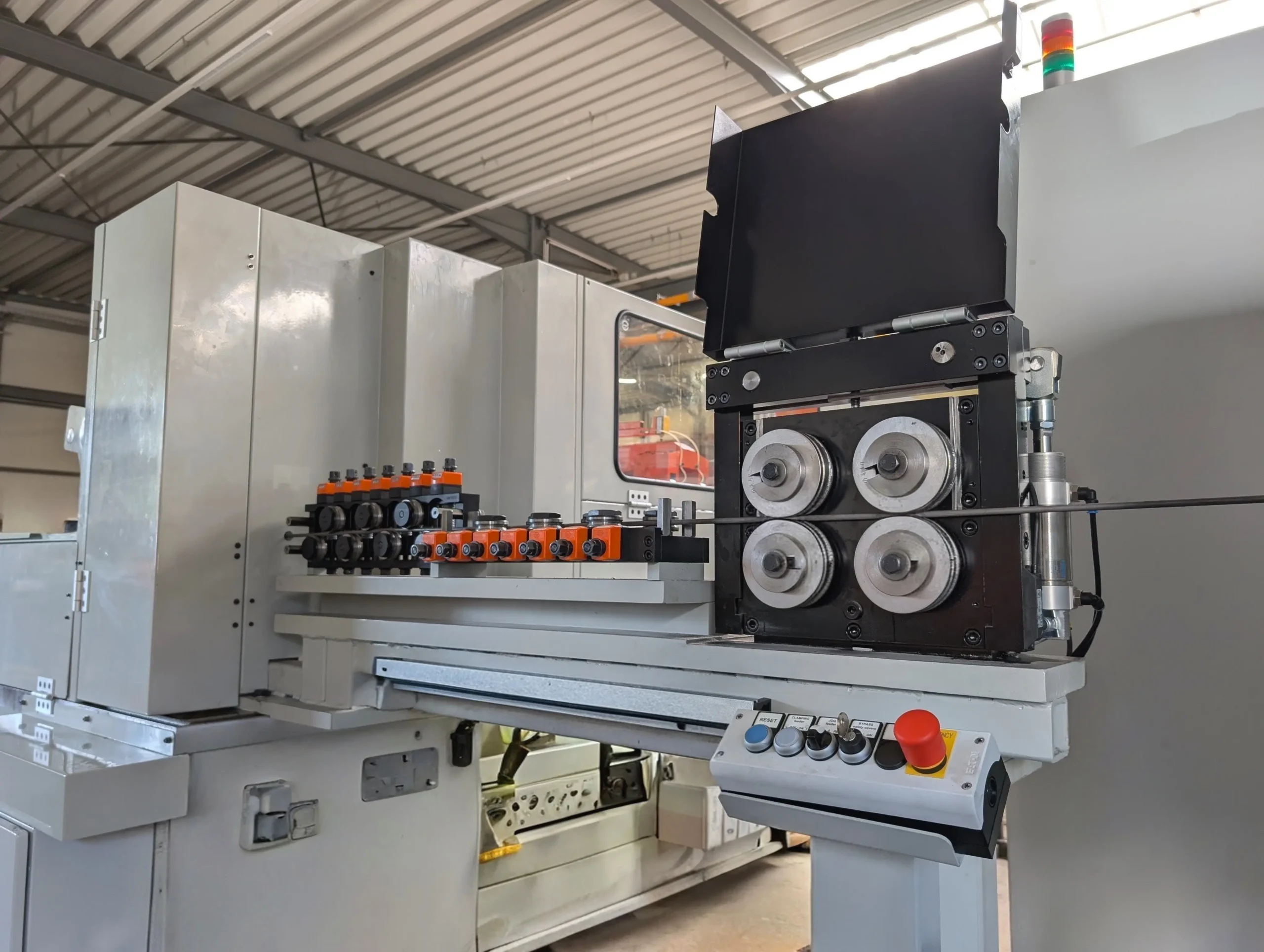 An automated wire feeding system with guided feed rollers, an integrated roller straightening unit, and a control panel for machine systems